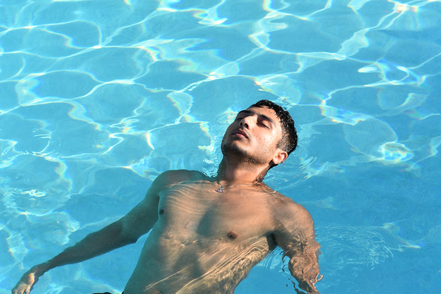 homme se relaxe sur le dos dans une piscine